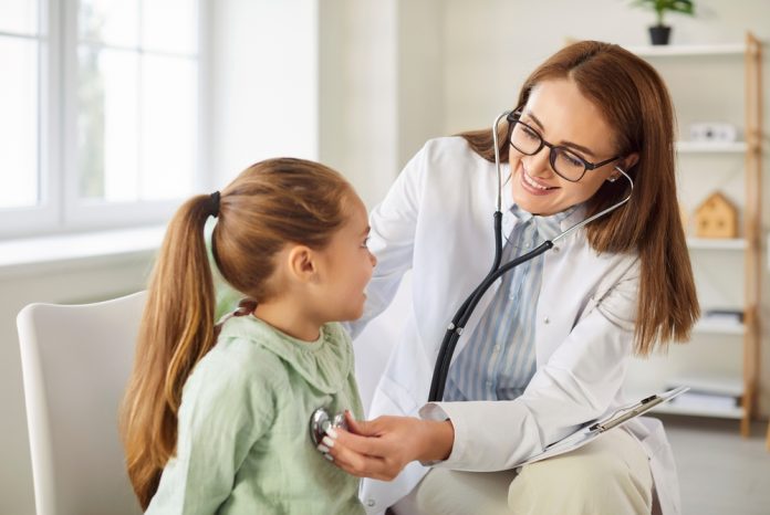 Un doctor pediatru examinând un copil