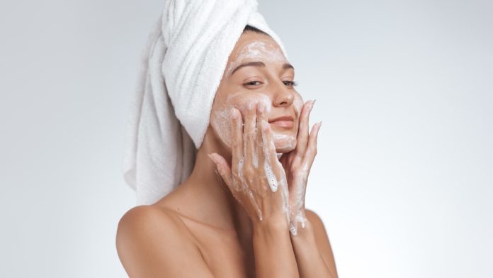 femeie foloseste pe fata produs exfoliant